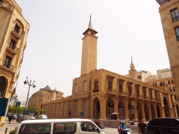 View of buildings and street in city against sky