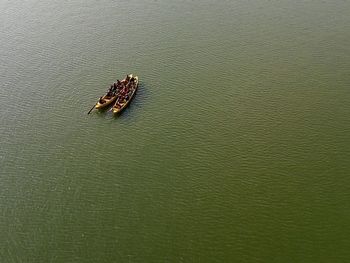 High angle view of people boating in green water