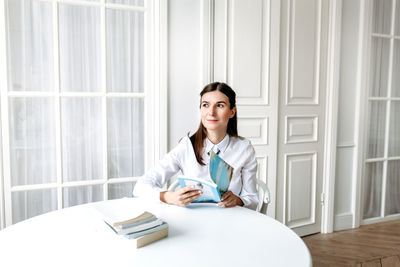 Portrait of a young woman sitting on table