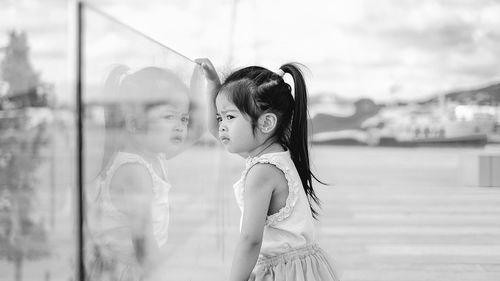 Side view of cute girl looking away while standing outdoors