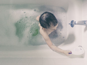 High angle view of girl in bathtub at home