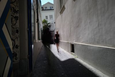 Rear view of man walking in front of building