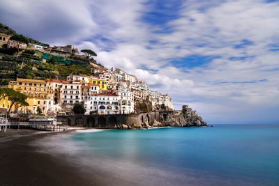 Scenic view of sea by cliff against sky