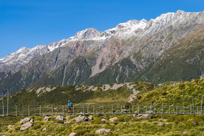 Hiker on footbridge at mount cook national park