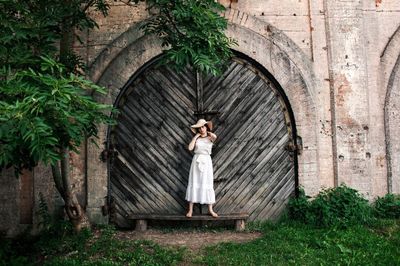 Woman standing on wooden wall