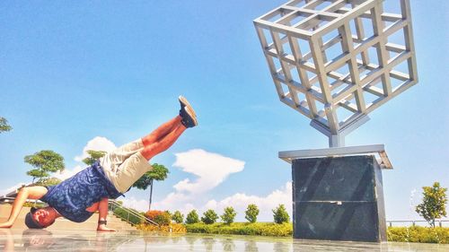 Low angle view of boy jumping over water against clear sky