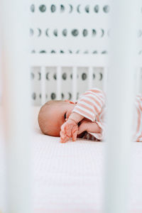 Closeup portrait of a baby girl laying in a modern crib