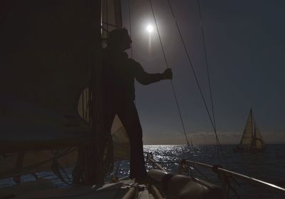 Man in boat against sky at night