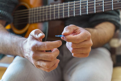 Midsection of man playing guitar