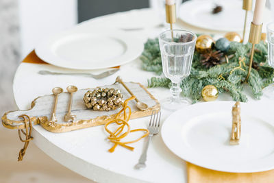 Christmas decor of the festive table for dinner. golden wreath of bells on a beautiful cutting board