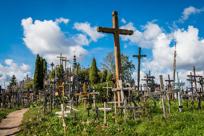 Cross on field against sky