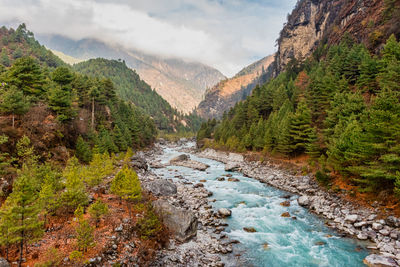 River flowing amidst mountains against sky