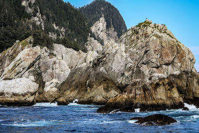 Rock formation in sea against sky