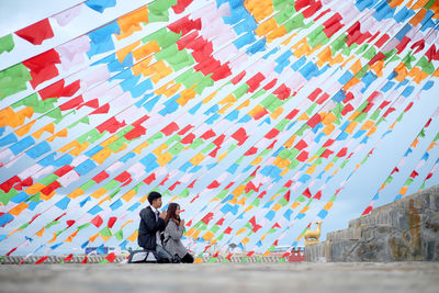 People on multi colored umbrellas against sky