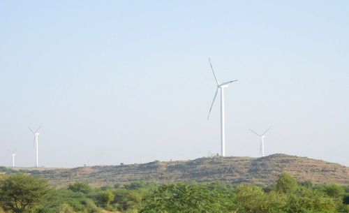 Low angle view of windmill on field against clear sky