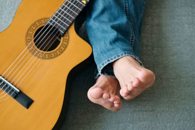 Low section of man playing guitar