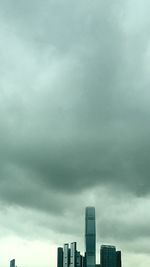 Low angle view of skyscrapers against cloudy sky