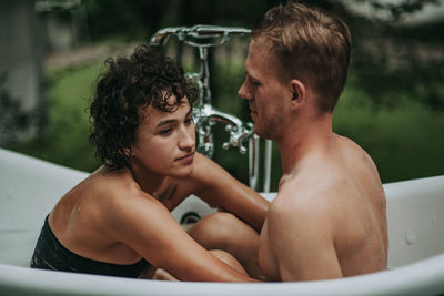 Couple in bathtub outdoors