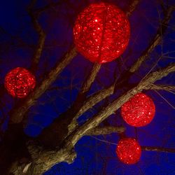 Low angle view of illuminated lanterns hanging against sky at night