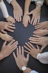 Directly above shot of multi-generation family placing hands in circle