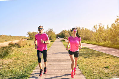 Fit couple running towards camera