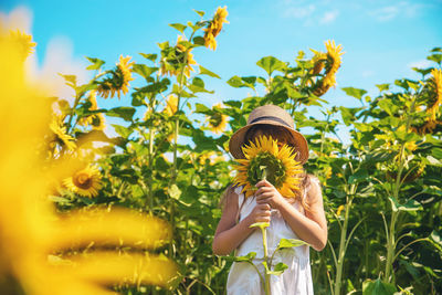 Girl with flower standing on field