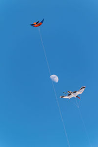 Low angle view of kite flying against clear blue sky