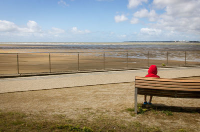 Little red riding hood sitting in front of the ocean