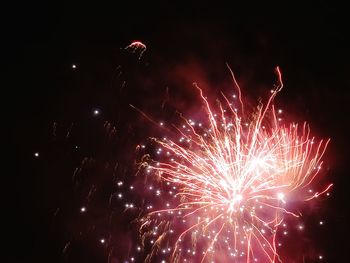 Low angle view of firework display at night