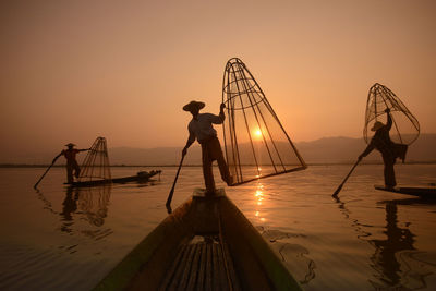 Silhouette of woman in sea at sunset