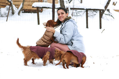 Portrait of woman with dogs in snow