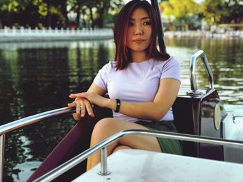 Portrait of woman sitting in boat against lake