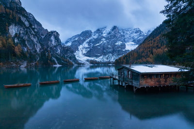 Scenic view of lake by snowcapped mountains against sky