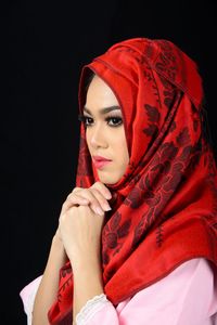 Portrait of beautiful young woman against black background