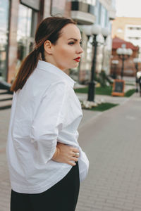 Side view of young woman standing on street