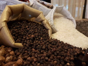 Close-up of black peppercorns and rice