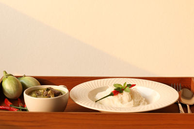 Close-up of fruits served on table against wall