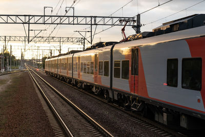 Express train leaves station reaching new destination to pick up and drop off passengers at sunset