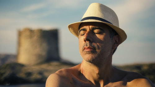 Portrait of man wearing hat against sky