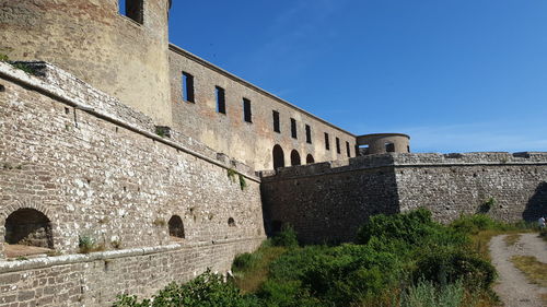 Low angle view of historic building against blue sky