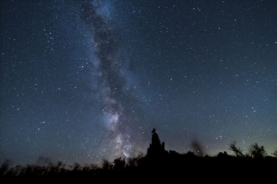 Low angle view of trees against sky at night