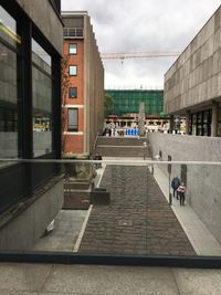 People on street amidst buildings in city