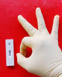 Close-up of human hand on red wall