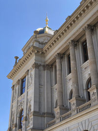 Low angle view of ornate building facade in prague under clear blue sky