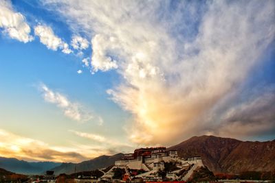 Town by mountains against sky at sunset