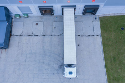 Modern logistics center, white van and trailers standingon ramp. aerial view