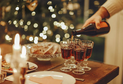 Cropped hand of woman holding wineglass on table