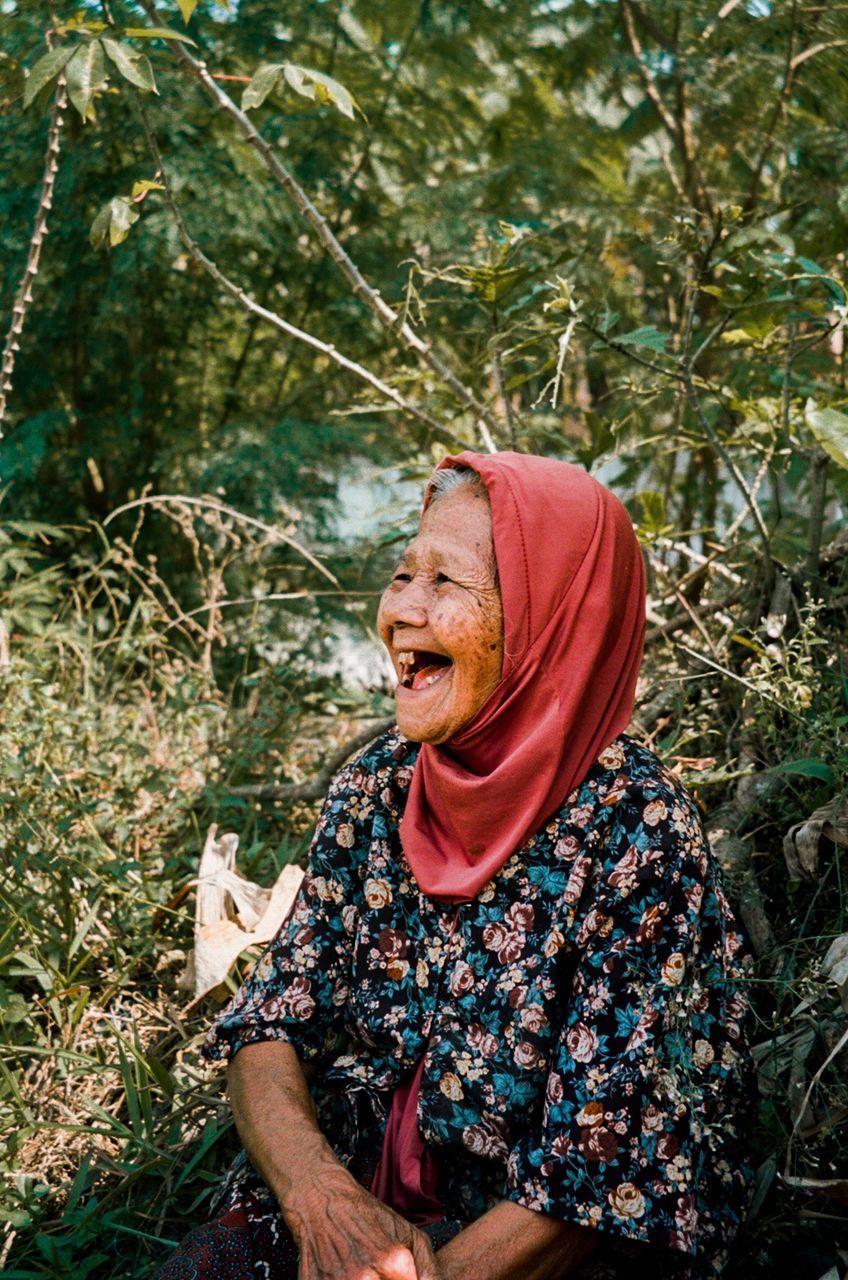 PORTRAIT OF A SMILING YOUNG WOMAN ON LAND