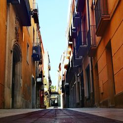 Low angle view of narrow alley amidst buildings in city