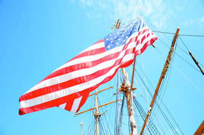 Low angle view of flag against blue sky